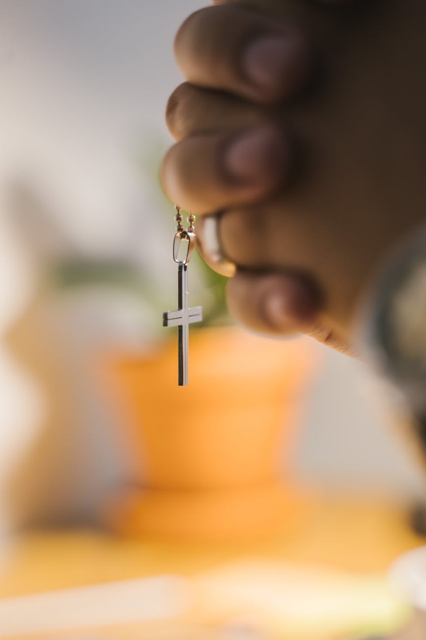 close up shot of a person holding a cross pendant