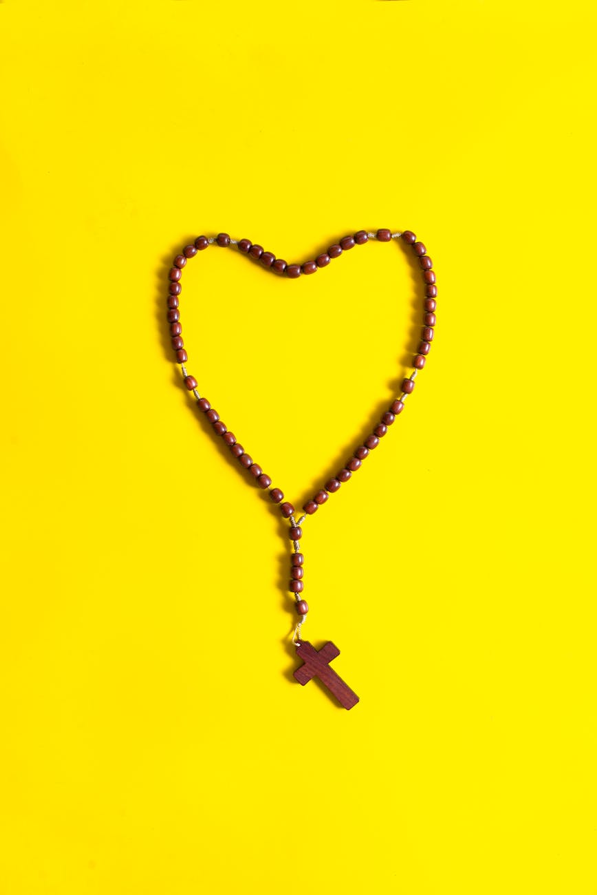 brown rosary on yellow surface